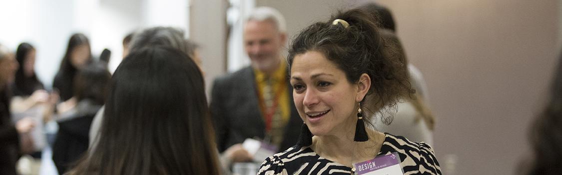 Employer networks with students at the Design Portfolio Review, Networking Reception.