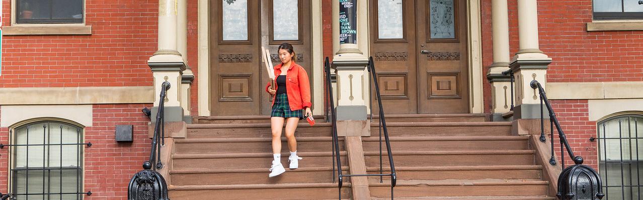 student walking with art supplies