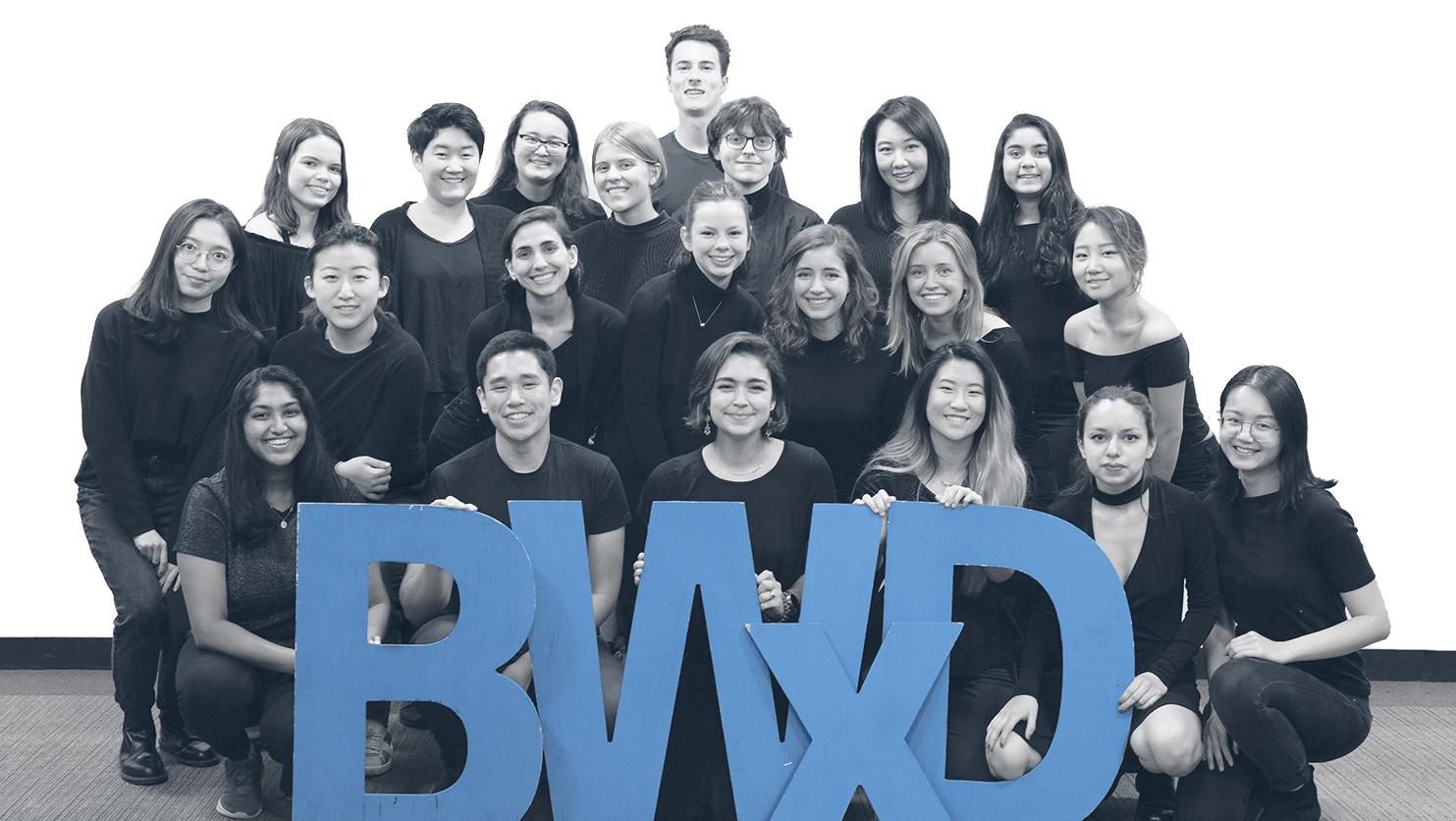Students at the Better World by Design conference pose with blue BWxD cutout letters