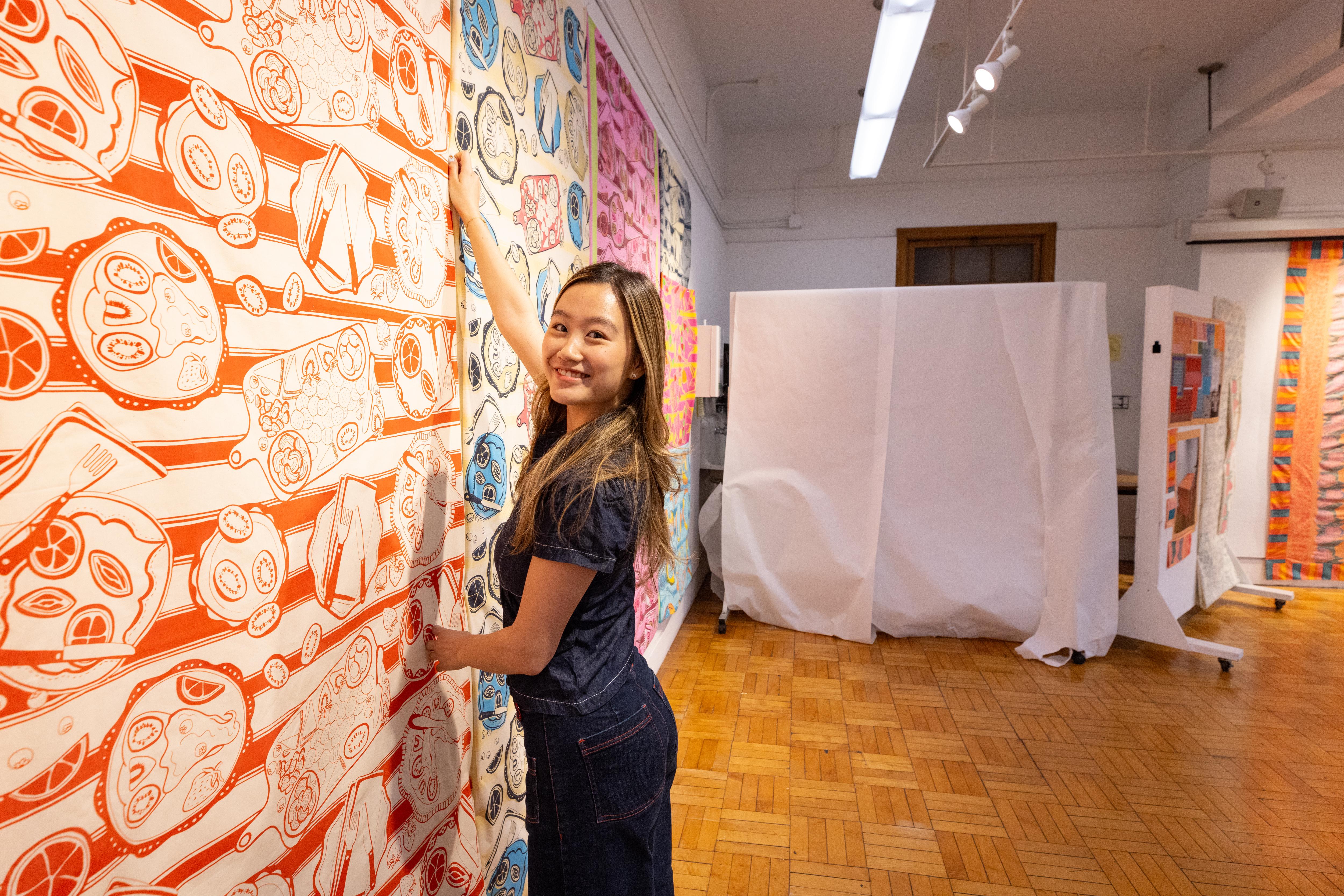 student displaying textile work