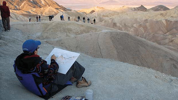 artist painting on sand dunes