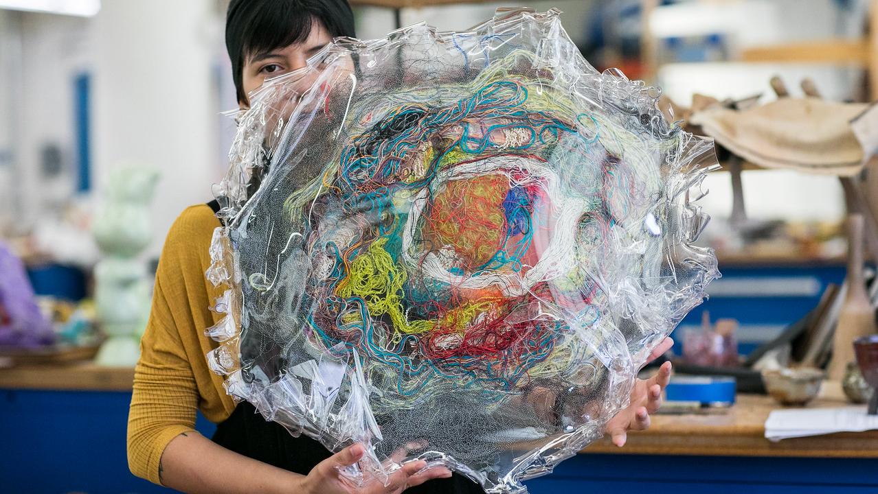 artists holding sculptural piece