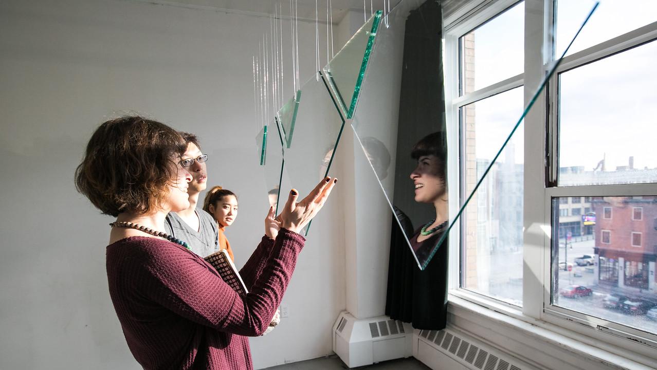 artist looking through glass piece